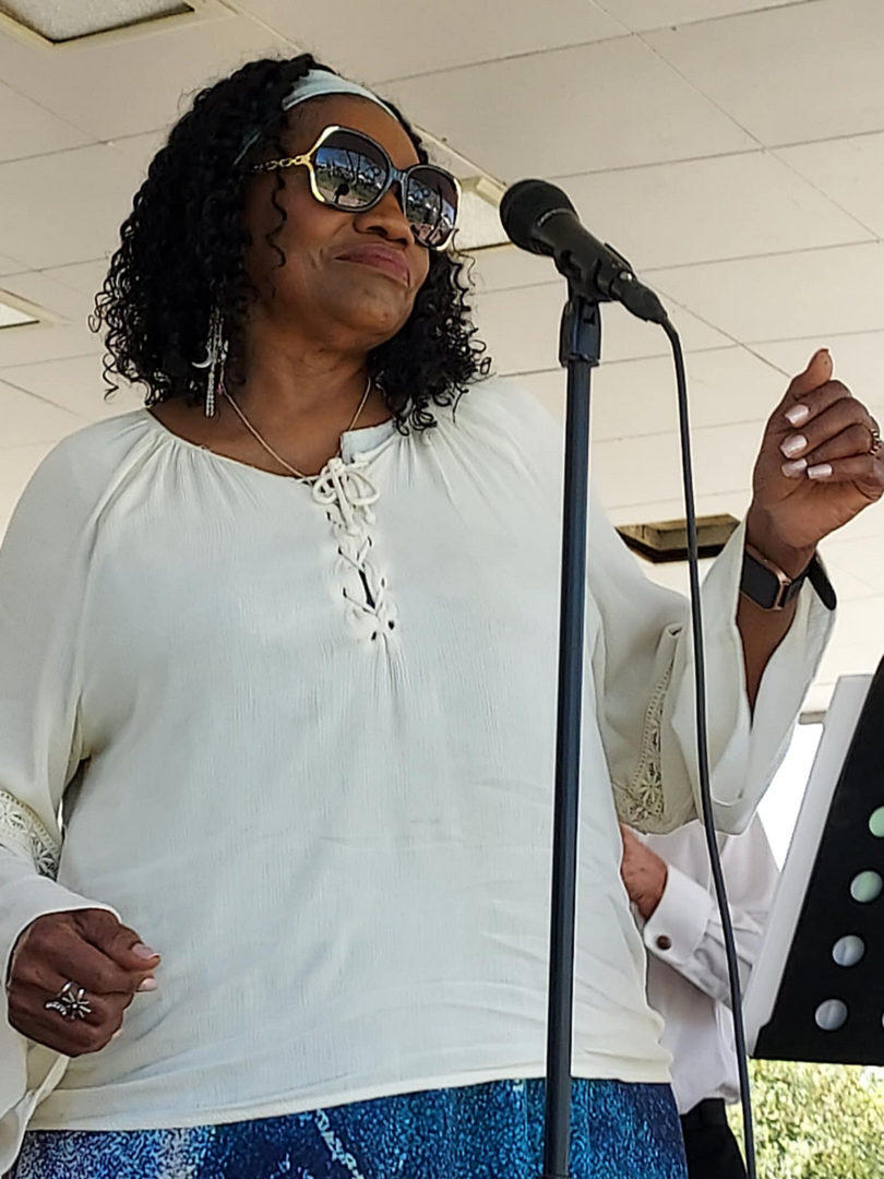 Female vocalist in white outfit with sunglasses